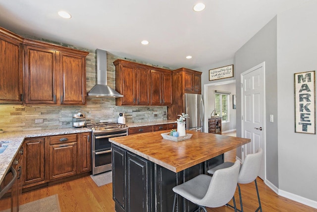 29990 Fehmarn Way, Genoa, IL 60135 - kitchen featuring wall chimney range hood, appliances with stainless steel finishes, light wood-style floors, decorative backsplash, and recessed lighting