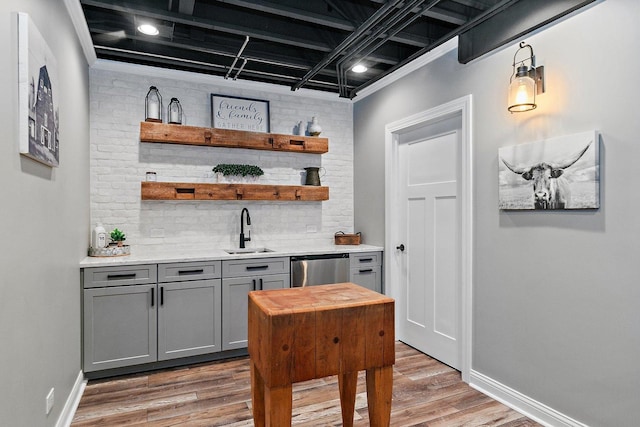 29990 Fehmarn Way, Genoa, IL 60135 - indoor wet bar with light wood-style flooring, decorative backsplash, stainless steel dishwasher, and hanging light fixtures