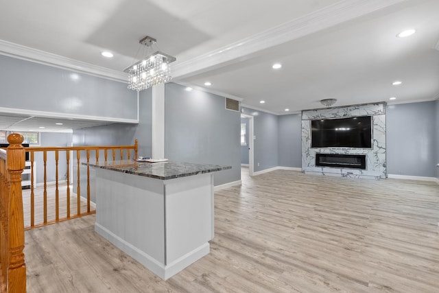 17317 Roy St, Lansing, IL 60438 - kitchen with ornamental molding, light wood-style flooring, dark stone counters, a fireplace, and recessed lighting