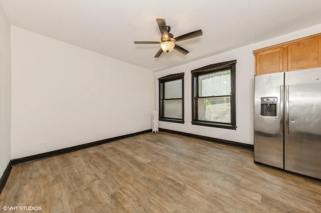 1455 E 56th St Unit 1E, Chicago, IL 60637 - spare room with radiator heating unit, light wood-type flooring, and a ceiling fan