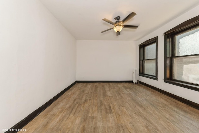 1455 E 56th St Unit 1E, Chicago, IL 60637 - empty room featuring radiator, wood finished floors, and ceiling fan
