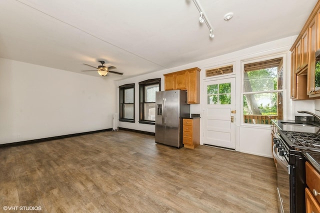 1455 E 56th St Unit 1E, Chicago, IL 60637 - kitchen featuring appliances with stainless steel finishes, radiator heating unit, dark countertops, and brown cabinets