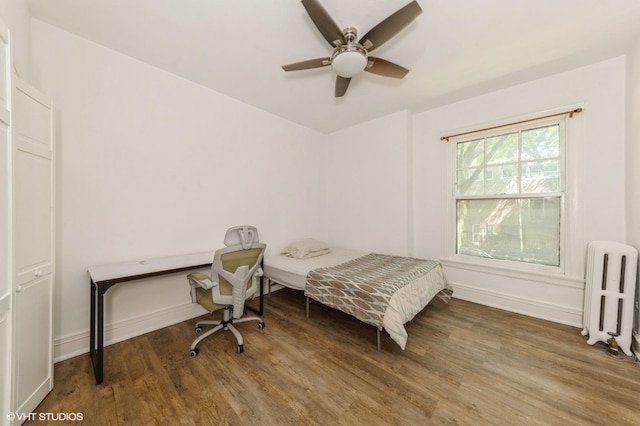 1455 E 56th St Unit 1E, Chicago, IL 60637 - bedroom featuring radiator heating unit, wood finished floors, and ceiling fan