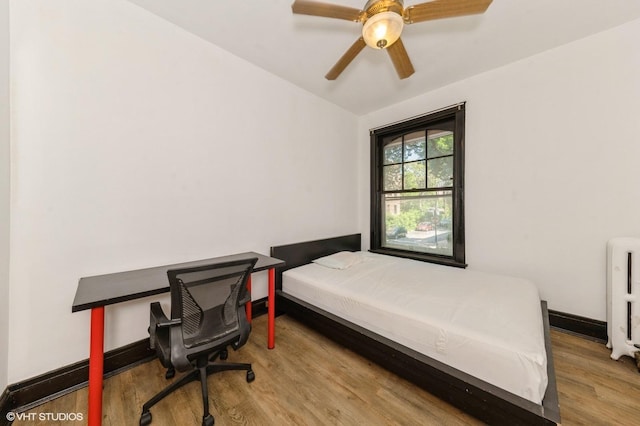 1455 E 56th St Unit 1E, Chicago, IL 60637 - bedroom with wood finished floors, radiator, and a ceiling fan