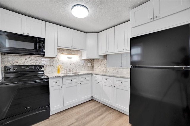 9444 Kelvin Ln Unit A-3211, Schiller Park, IL 60176 - kitchen featuring black appliances, white cabinets, light wood-type flooring, light stone countertops, and a textured ceiling