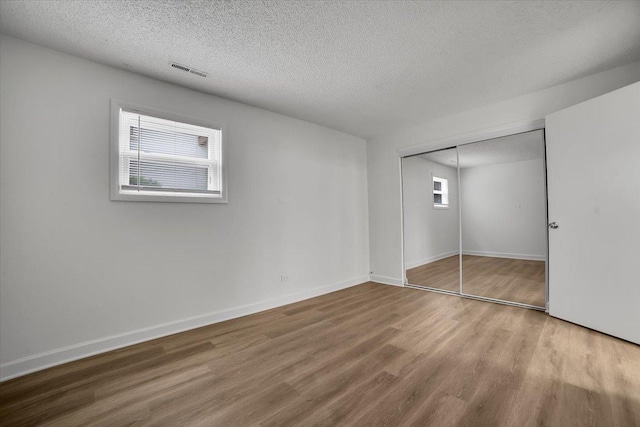 9444 Kelvin Ln Unit A-3211, Schiller Park, IL 60176 - unfurnished bedroom with wood finished floors, a textured ceiling, and a closet