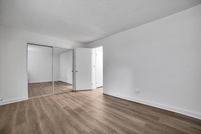 9444 Kelvin Ln Unit A-3211, Schiller Park, IL 60176 - unfurnished bedroom with wood finished floors, a closet, and a textured ceiling