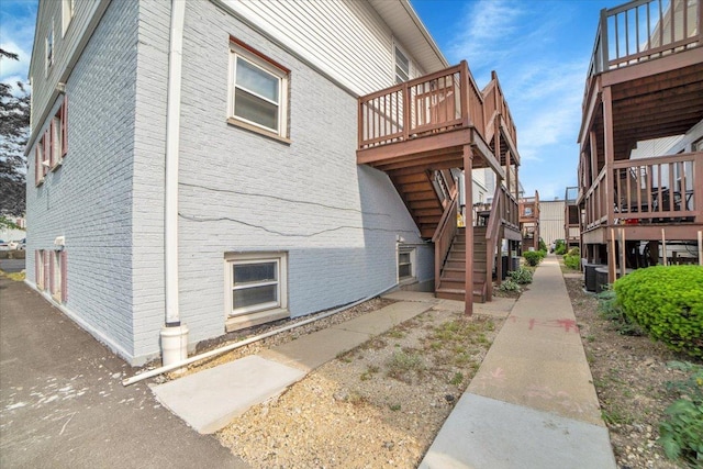 9444 Kelvin Ln Unit A-3211, Schiller Park, IL 60176 - view of side of property with stairway, a wooden deck, and brick siding