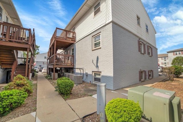 9444 Kelvin Ln Unit A-3211, Schiller Park, IL 60176 - view of side of property featuring stairs, a wooden deck, and brick siding