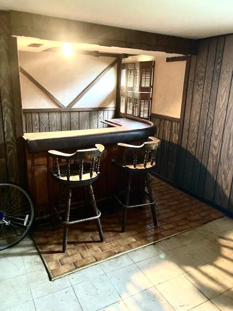 14238 S Manistee Ave, Burnham, IL 60633 - indoor bar with wood walls, a wainscoted wall, and tile patterned floors