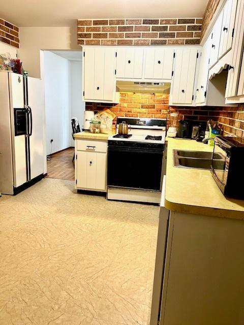 14238 S Manistee Ave, Burnham, IL 60633 - kitchen with white appliances, under cabinet range hood, light countertops, tasteful backsplash, and white cabinets
