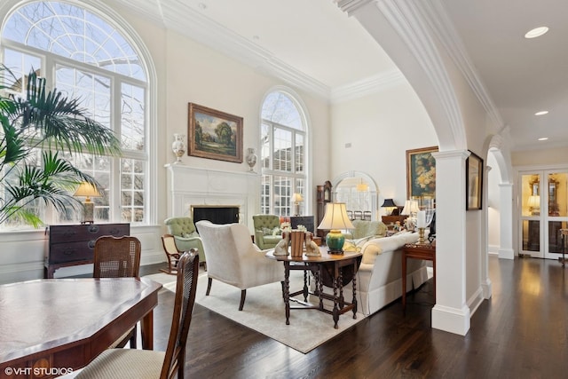 475 Red Fox Ln, Lake Forest, IL 60045 - living room with decorative columns, arched walkways, a fireplace, dark wood finished floors, and crown molding