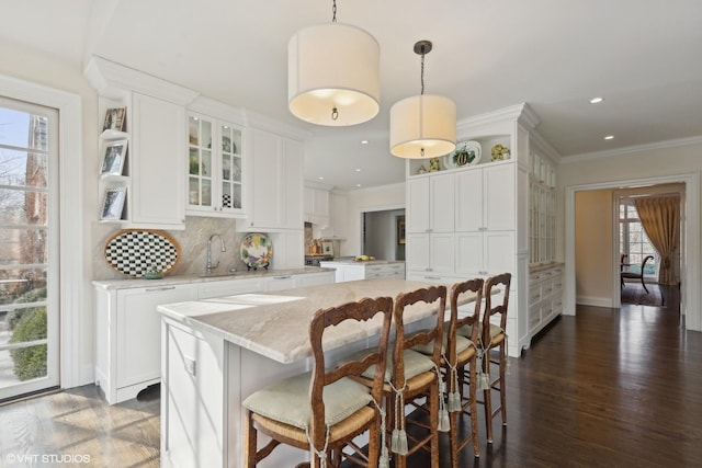 475 Red Fox Ln, Lake Forest, IL 60045 - kitchen with decorative backsplash, white cabinets, crown molding, glass insert cabinets, and a breakfast bar