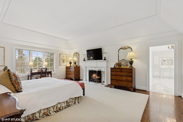 475 Red Fox Ln, Lake Forest, IL 60045 - bedroom featuring wood finished floors, a raised ceiling, a warm lit fireplace, connected bathroom, and ornamental molding