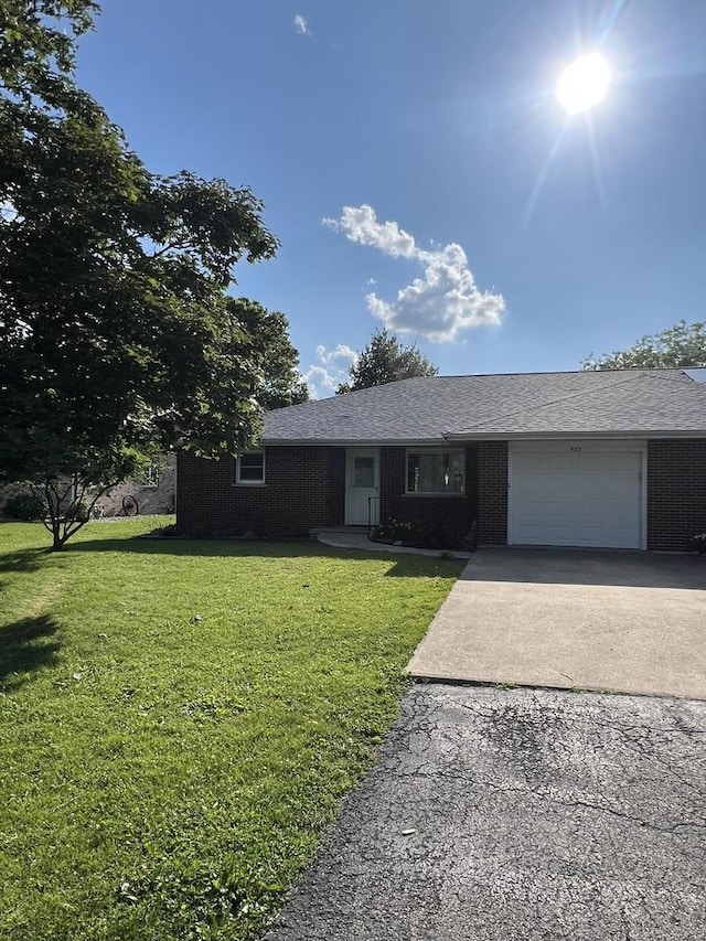 422 N 4th St, Cissna Park, IL 60924 - ranch-style home with a garage, driveway, a front lawn, and brick siding