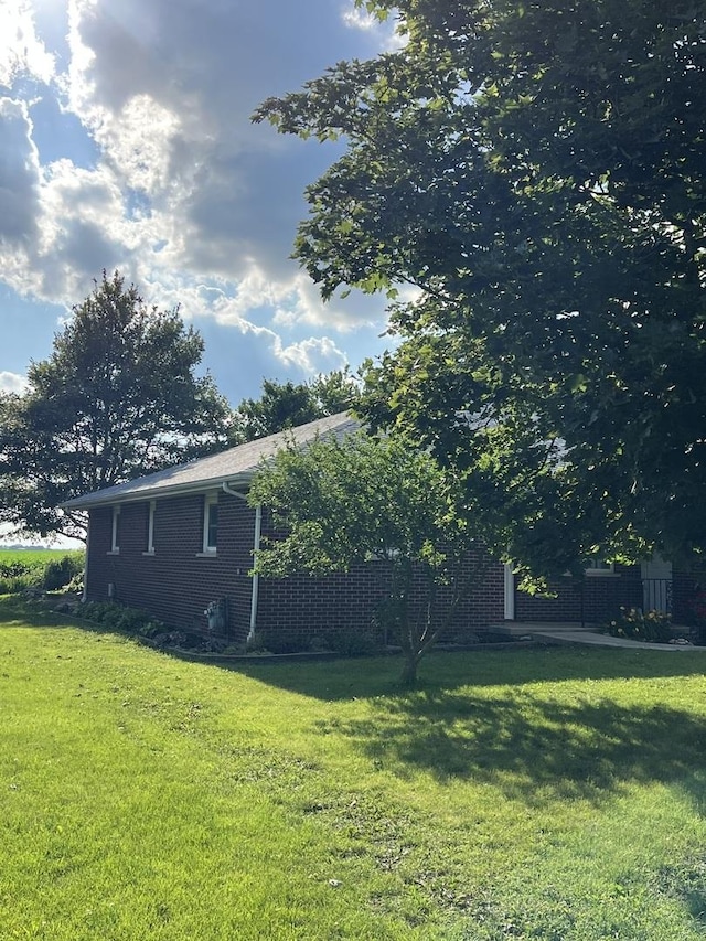 422 N 4th St, Cissna Park, IL 60924 - view of home's exterior featuring a yard and brick siding