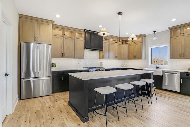 1104 Walter St, Lemont, IL 60439 - kitchen featuring appliances with stainless steel finishes, tasteful backsplash, a kitchen island, a breakfast bar, and light wood-type flooring
