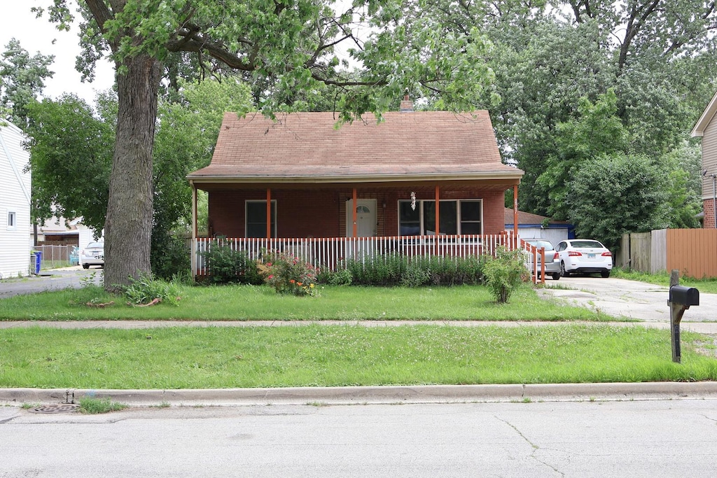 6807 S 79th Ave, Bridgeview, IL 60455 - view of front of house featuring a porch, driveway, and a chimney