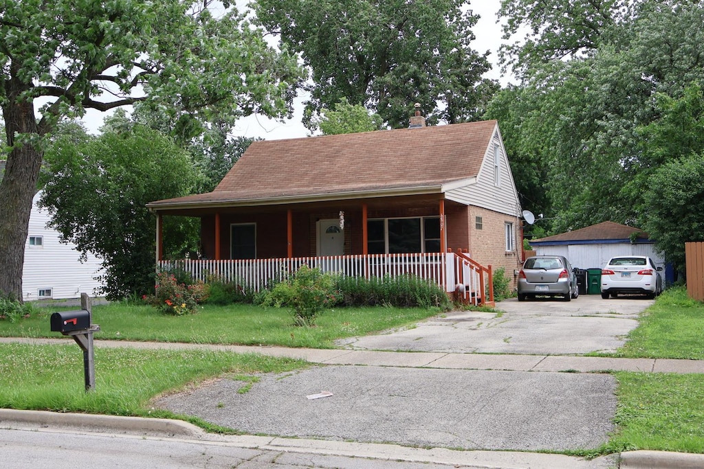 6807 S 79th Ave, Bridgeview, IL 60455 - view of front facade featuring a porch, a chimney, brick siding, and a front lawn