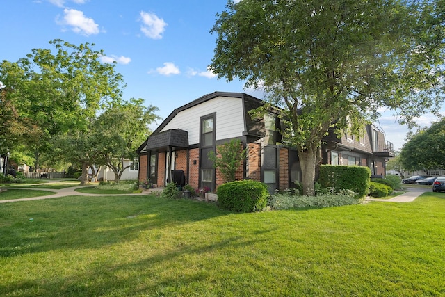 1024 Inverrary Ln Unit 1024, Deerfield, IL 60015 - view of front facade with brick siding, a front yard, and a gambrel roof
