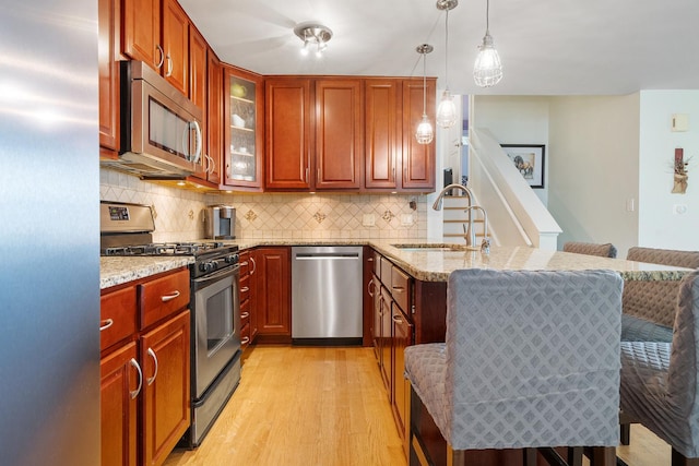 1024 Inverrary Ln Unit 1024, Deerfield, IL 60015 - kitchen featuring stainless steel appliances, light wood-style flooring, a peninsula, and light stone counters