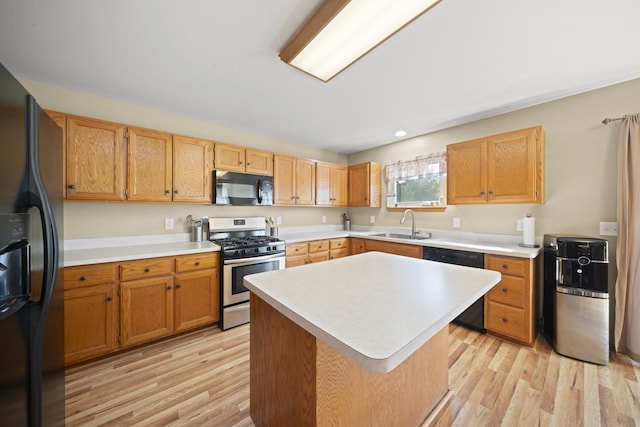 1654 Hilda Dr, Lake Holiday, IL 60548 - kitchen featuring black appliances, light countertops, light wood-style flooring, and a center island