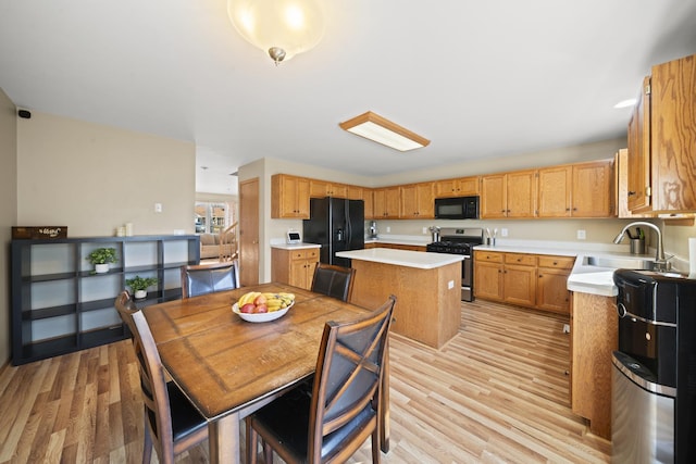 1654 Hilda Dr, Lake Holiday, IL 60548 - kitchen featuring black appliances, a center island, light countertops, and light wood-style flooring