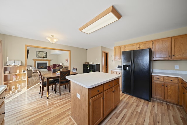1654 Hilda Dr, Lake Holiday, IL 60548 - kitchen featuring black fridge with ice dispenser, light wood-type flooring, light countertops, and a center island