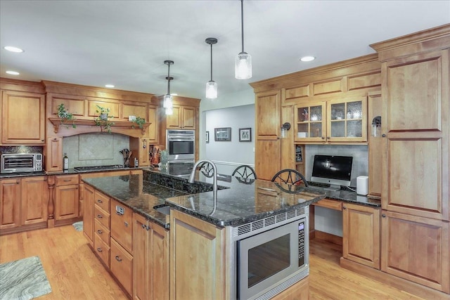 1490 S Ridge Rd, Lake Forest, IL 60045 - kitchen featuring appliances with stainless steel finishes, light wood-style flooring, a kitchen island with sink, decorative backsplash, and recessed lighting