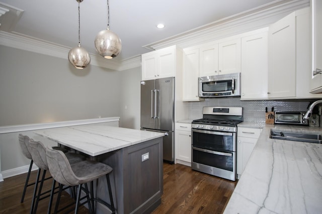 323 W Schiller St Unit 1W, Chicago, IL 60610 - kitchen with stainless steel appliances, decorative backsplash, crown molding, a kitchen island, and a breakfast bar area