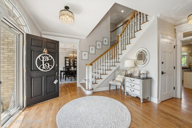 5609 Farmbrook Ln, Crystal Lake, IL 60014 - foyer featuring a chandelier, stairway, light wood-style floors, and crown molding