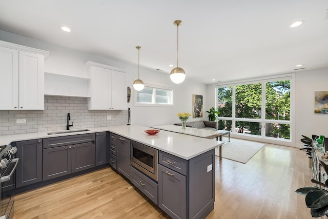 879 N Hermitage Ave Unit 2, Chicago, IL 60622 - kitchen featuring appliances with stainless steel finishes, gray cabinetry, a peninsula, tasteful backsplash, and recessed lighting