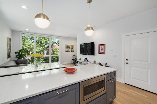 879 N Hermitage Ave Unit 2, Chicago, IL 60622 - kitchen with stainless steel microwave, gray cabinets, light wood-style flooring, light countertops, and recessed lighting