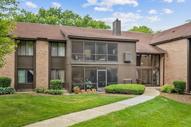 740 Saint Andrews Ln Unit 13, Crystal Lake, IL 60014 - rear view of house with a chimney, a yard, brick siding, and a shingled roof