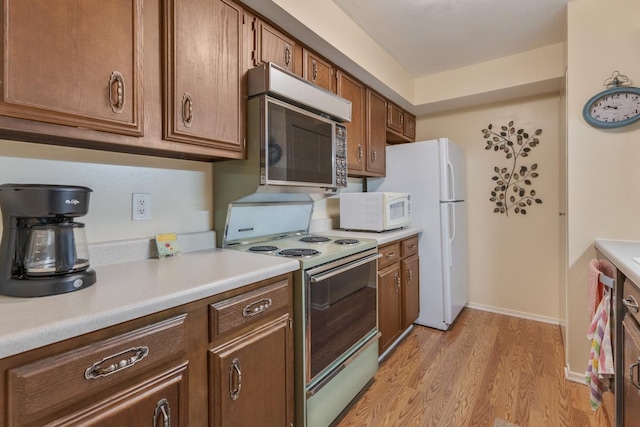 740 Saint Andrews Ln Unit 13, Crystal Lake, IL 60014 - kitchen featuring white appliances, light wood-type flooring, light countertops, and brown cabinets