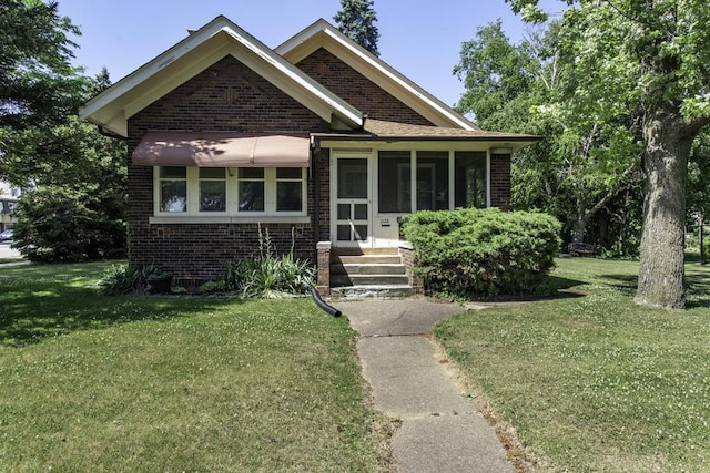 1128 Shiloh Blvd, Zion, IL 60099 - bungalow featuring brick siding, a front yard, a sunroom, and entry steps