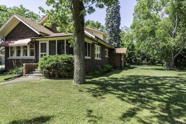 1128 Shiloh Blvd, Zion, IL 60099 - view of side of home with brick siding, a lawn, a sunroom, and roof with shingles