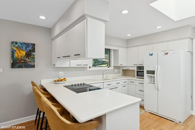 332 S Elmwood Ln, Palatine, IL 60067 - kitchen with white refrigerator with ice dispenser, a peninsula, stainless steel microwave, black electric stovetop, and a breakfast bar area