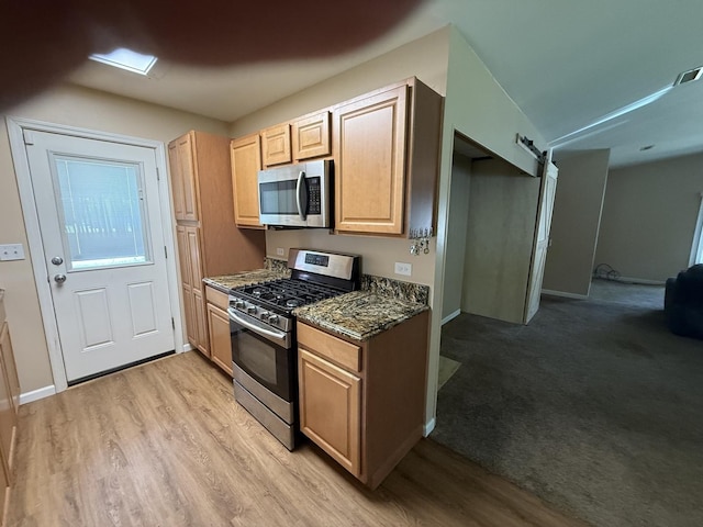 1006 Totem Trl, Mchenry, IL 60051 - kitchen with appliances with stainless steel finishes, light wood finished floors, light brown cabinetry, and dark stone counters