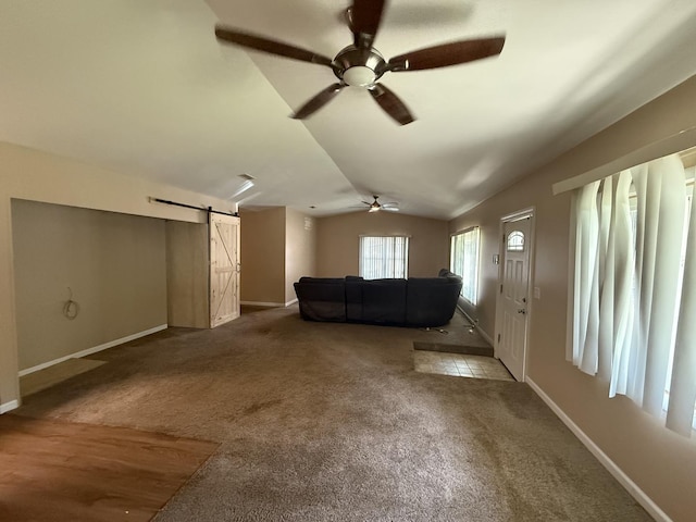 1006 Totem Trl, Mchenry, IL 60051 - unfurnished living room with a barn door, a ceiling fan, vaulted ceiling, and carpet