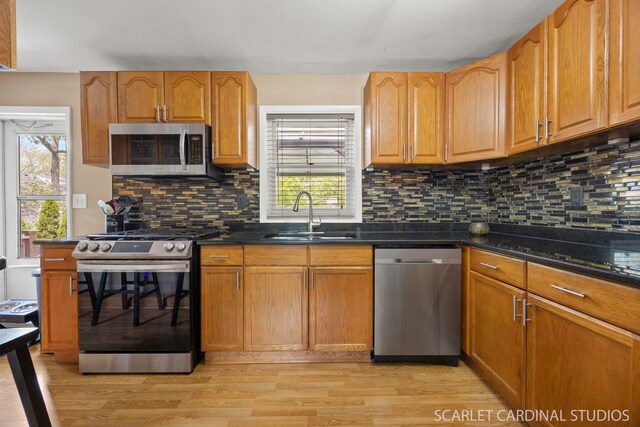 14 E Madison St, Villa Park, IL 60181 - kitchen featuring appliances with stainless steel finishes, light wood finished floors, tasteful backsplash, and dark stone countertops