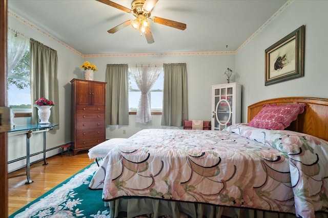 13079 N 1800 E Rd, Pontiac, IL 61764 - bedroom with baseboard heating, multiple windows, light wood-type flooring, crown molding, and ceiling fan
