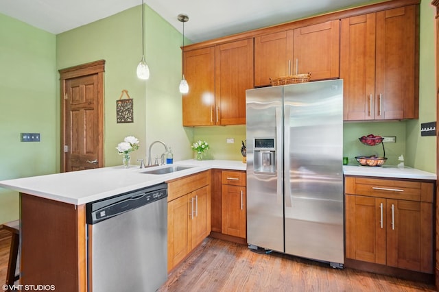 500 Fair Oaks Ave, Oak Park, IL 60302 - kitchen featuring stainless steel appliances, a peninsula, brown cabinetry, light countertops, and light wood-style flooring