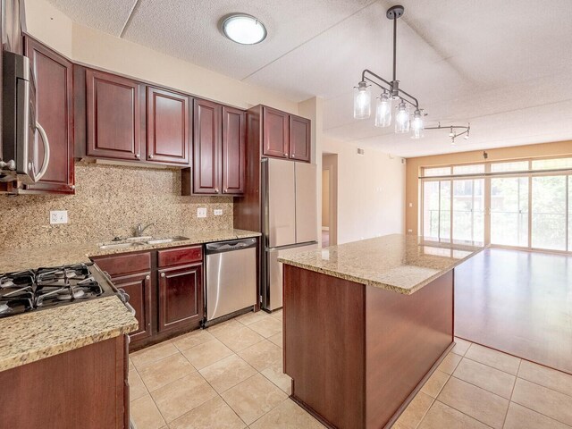 1670 Mill St Unit 208, Des Plaines, IL 60016 - kitchen with stainless steel appliances, decorative backsplash, light tile patterned floors, hanging light fixtures, and light stone counters