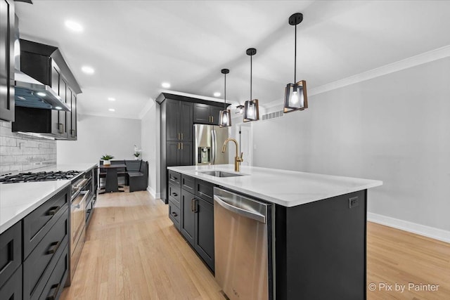 27W075 Fleming Dr, Winfield, IL 60190 - kitchen featuring appliances with stainless steel finishes, crown molding, backsplash, a kitchen island with sink, and light wood-style floors