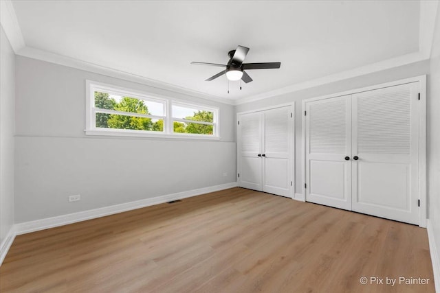 27W075 Fleming Dr, Winfield, IL 60190 - unfurnished bedroom featuring two closets, light wood-style floors, ornamental molding, and a ceiling fan