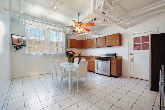 1360 E Madison Park Unit B, Chicago, IL 60615 - kitchen featuring gas range oven, freestanding refrigerator, brown cabinets, a ceiling fan, and light tile patterned floors