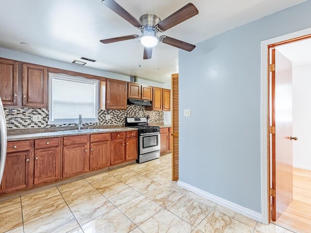 14732 Dorchester Ave, Dolton, IL 60419 - kitchen with stainless steel gas stove, decorative backsplash, under cabinet range hood, brown cabinets, and ceiling fan