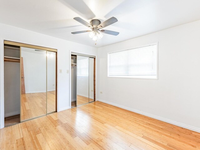 14732 Dorchester Ave, Dolton, IL 60419 - unfurnished bedroom featuring multiple closets, light wood finished floors, and ceiling fan