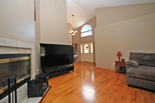 135 Miller Rd, Lake Zurich, IL 60047 - living room featuring high vaulted ceiling, a fireplace, a chandelier, and light wood-style flooring